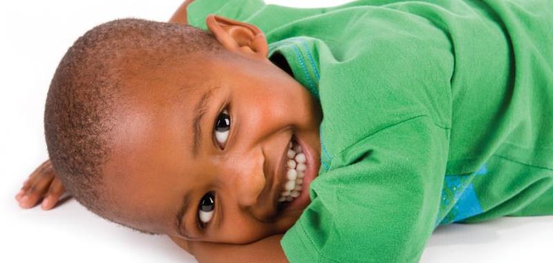 Boy laying down with green shirt on
