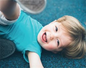 Little boy in blue on his back
