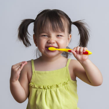 Little Girl with pig tails brushing her teeth