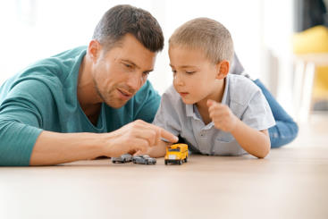 Man and boy playing with die-cast cars Man and boy playing with die-cast cars